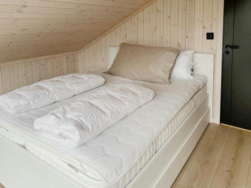 a large white bed in a room with wooden walls at Authentic Cabin Life With Løefjell View in Rysstad
