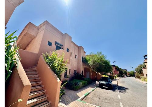 a building with a car parked in front of it at Duplex Luxe avec Rooftop, 3 Piscines, 2 Chambres, Atlas Golf Marrakech in Marrakech
