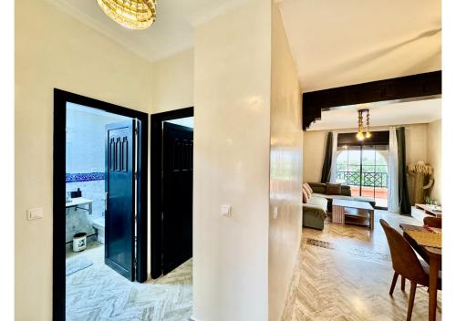 a living room with a door open to a living room at Duplex Luxe avec Rooftop, 3 Piscines, 2 Chambres, Atlas Golf Marrakech in Marrakech