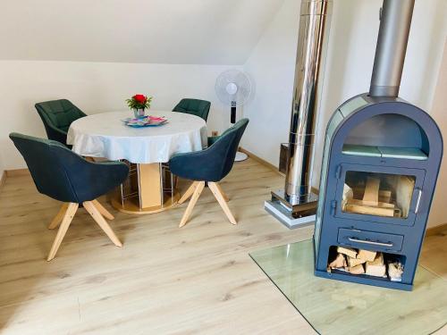 a dining room with a table and a wood stove at Ferienwohnung Evelyn und Reinhard Himmler in Pleinfeld