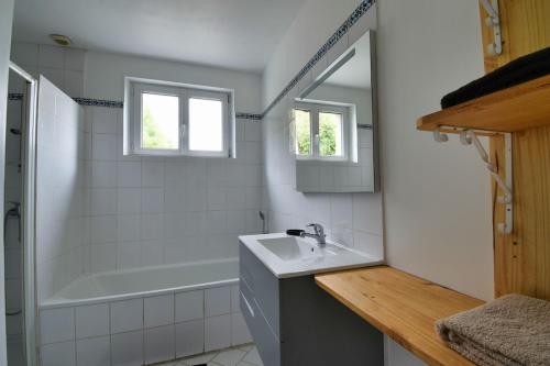 Un baño con lavabo, bañera y espejo. en La belle étoile 2 1à6pers 3ch 5lits parking privé, en Brou