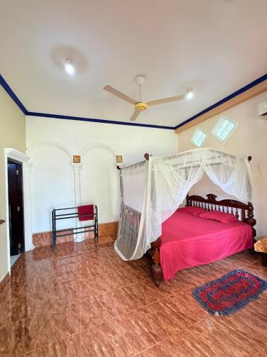 a bedroom with a bed with a mosquito net at Utopia Hikka in Hikkaduwa