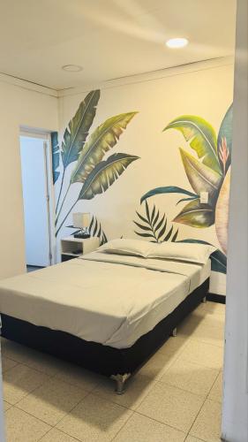 a bedroom with a bed with a mural on the wall at Baku Laureles Hostel in Medellín
