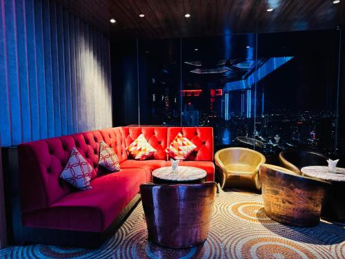 a living room with a red couch and two tables at THE PLATINUM KLCC by COZY STAY in Kuala Lumpur