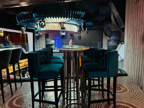 a bar with green chairs and a round table at THE PLATINUM KLCC by COZY STAY in Kuala Lumpur
