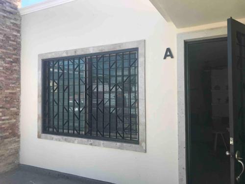 a window with bars on the side of a building at La Hidalgo, Departamento A in Chapala