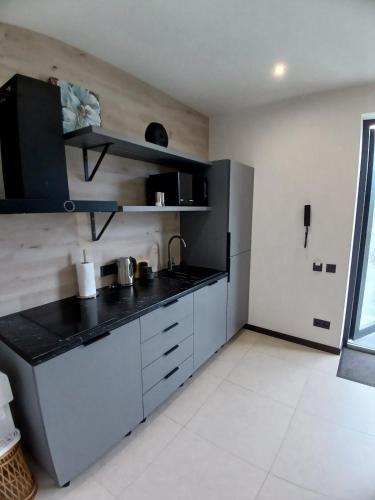 a kitchen with white cabinets and a black counter top at EcoBerghaus - Котеджне містечко in Bukovel