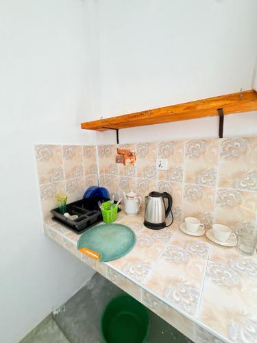a kitchen counter with a stove and a tea kettle at Utopia Hikka in Hikkaduwa