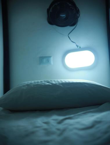 a bedroom with a bed with a blue light at Baku Laureles Hostel in Medellín