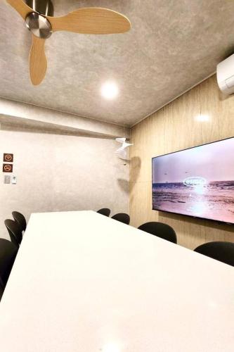 a conference room with a white table and a flat screen tv at Beaver Stay, Bosu in Busan