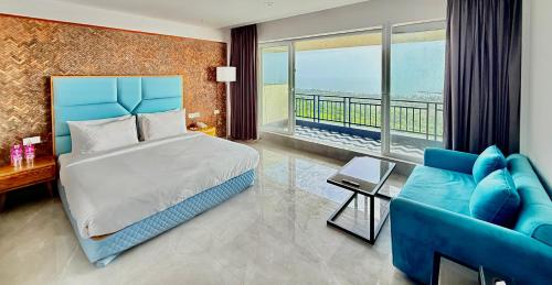 a bedroom with a blue bed and a blue couch at Regenta Waterfront Resort, Dapoli in Dapoli