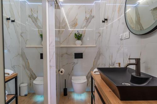 a bathroom with a sink and a toilet and a mirror at Apartman Mirakul in Korčula