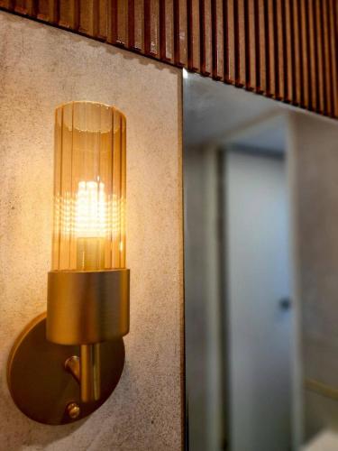 a light on the side of a wall with a mirror at Beaver Stay, Bosu in Busan