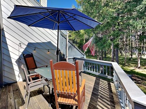a table and chairs with an umbrella on a deck at Arrowhead Village 13 in Thayerville