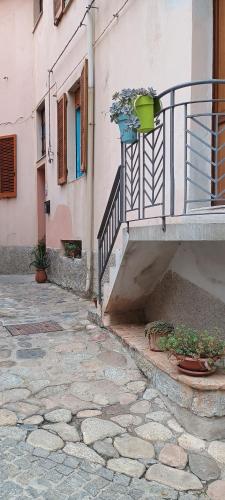 a building with a balcony with buckets on it at Sa Omu 'Eccia in Villagrande Strisaili