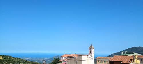 a view of a town with a church and the ocean at Sa Omu 'Eccia in Villagrande Strisaili