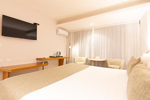 a hotel room with a large bed and a desk at Design Suites Calafate in El Calafate