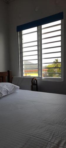 a bedroom with a bed and a large window at Ocean breeze in Galle