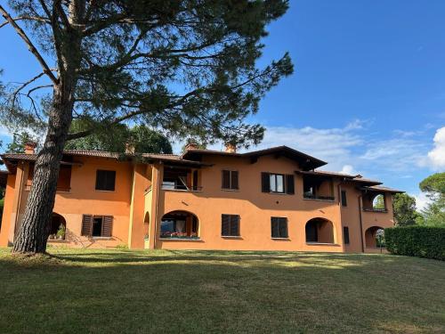 an orange house with a tree in front of it at Colonia del Lago - Trilocale - Menaggio in Menaggio