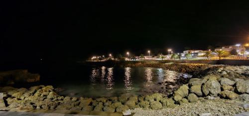 a body of water at night with buildings and lights at Spacieux haut de villa proche plage in Anse-Bertrand