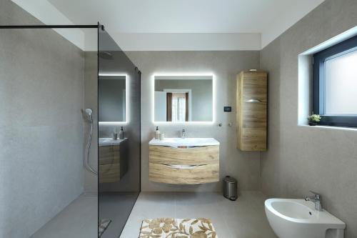 a bathroom with a sink and a toilet and a mirror at Cherry House in Medulin