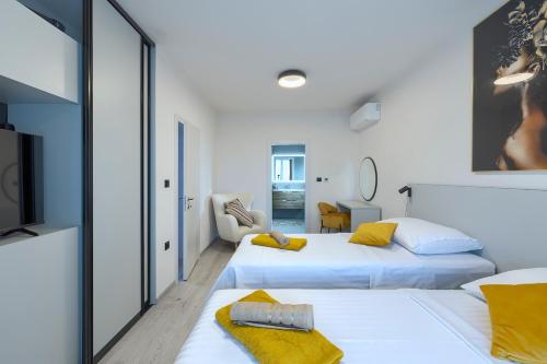 a room with two beds with yellow pillows at Cherry House in Medulin