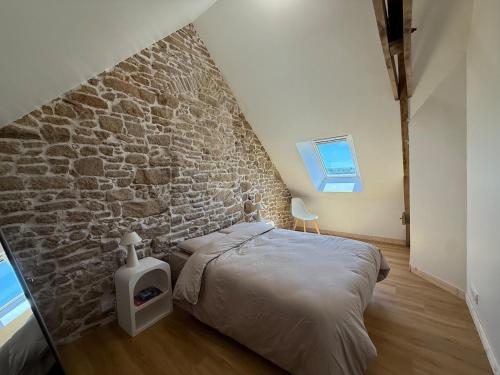 a bedroom with a stone wall and a bed at Nature break in a farmhouse near Vannes in Grand-Champ