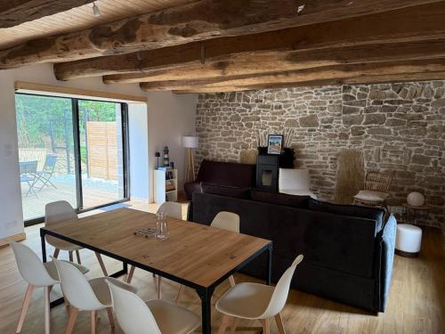 a living room with a wooden table and chairs at Nature break in a farmhouse near Vannes in Grand-Champ