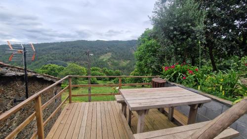 a wooden deck with a wooden picnic table on a balcony at Casa do Forno in Miranda do Corvo