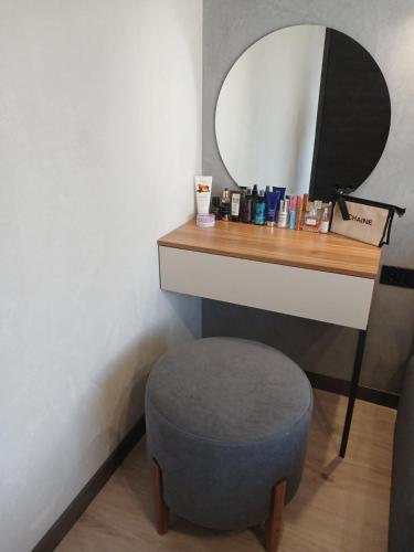 a vanity with a round mirror and a stool at EcoBerghaus - Котеджне містечко in Bukovel