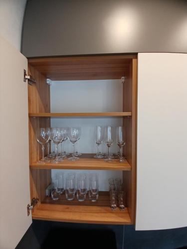 a cabinet filled with wine glasses in a room at EcoBerghaus - Котеджне містечко in Bukovel