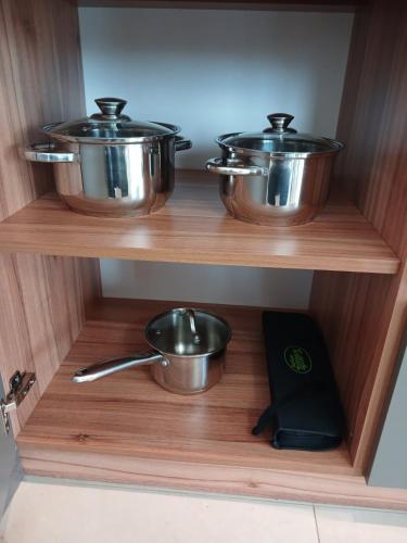 two pots and pans sitting on a wooden shelf at EcoBerghaus - Котеджне містечко in Bukovel