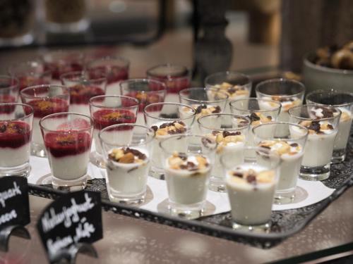 a group of cups filled with desserts on a table at Leonardo Hotel Hamburg City Nord in Hamburg