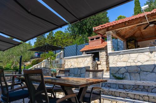 an outdoor patio with a wooden table and chairs at Apartman Mirakul in Korčula