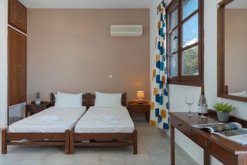 a bedroom with a bed and a table and a window at Frantzis Studio 2 - Nisyros in Páloi