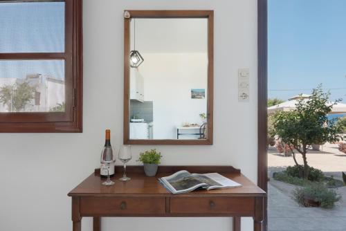 a table with a mirror and a bottle of wine at Frantzis Studio 2 - Nisyros in Páloi