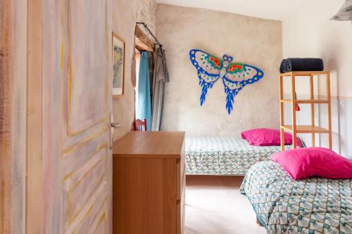 a bedroom with two beds and a butterfly on the wall at Gîte L'Atelier in Saint Martin sur Lavezon