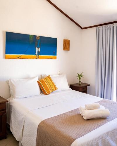 a bedroom with two beds and a painting on the wall at Suri Búzios Hotel in Búzios