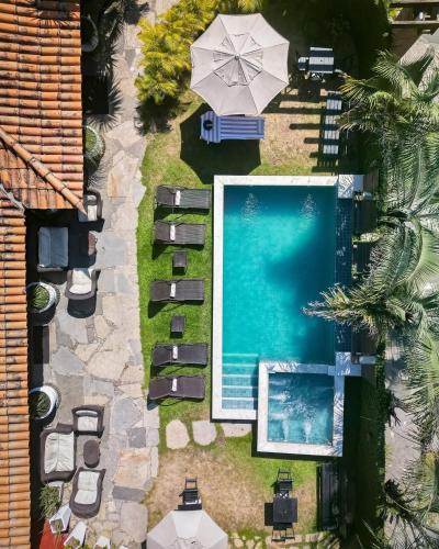 an overhead view of a swimming pool with an umbrella at Suri Búzios Hotel in Búzios