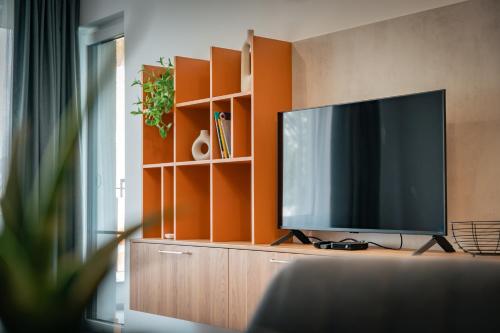 a flat screen tv sitting on top of a wooden cabinet at TRINAVIS Boutique Apartments, OWN PRIVATE PARKING, City Center, Entire Apartment in Veliko Tŭrnovo