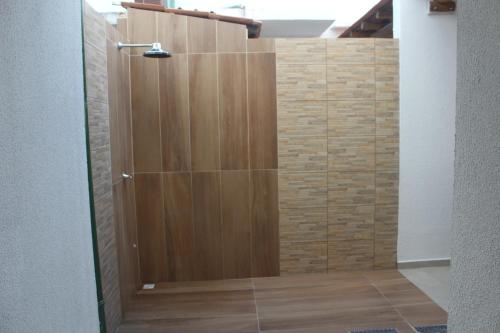 doccia con porta in legno in camera di Mer Bleue du Français a Marechal Deodoro