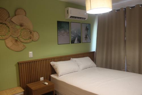 una piccola camera da letto con un letto con lenzuola bianche di Mer Bleue du Français a Marechal Deodoro