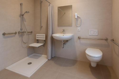 a bathroom with a toilet and a sink at LA MAISON DU NORD - Hotel Garni in Cuxhaven