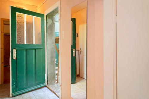 a green door in a room with a mirror at Altes Polchower Pfarrhaus 