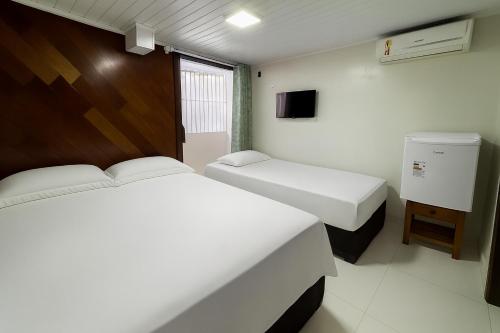 a room with two beds and a tv in it at Hotel COP 30 in Belém