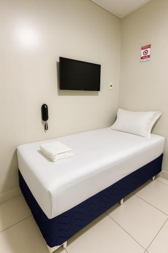 a bed in a room with a tv on the wall at Hotel COP 30 in Belém
