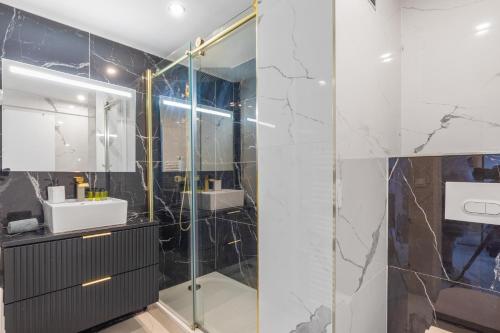 une salle de bain avec une douche en verre et un lavabo dans l'établissement Au coeur de Juan Les Pins L'Empire 8 couchages, à Antibes