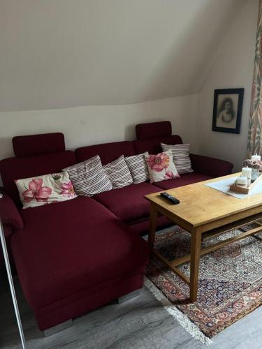 a living room with a red couch and a coffee table at Das blaue Haus in Zeltingen-Rachtig