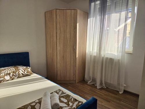 Un dormitorio con una cama y un armario de madera. en Airport 2BR Suite Filip, en Beograd