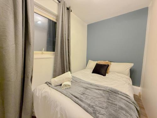 a small bedroom with a bed with a window at Elegant 2BR Flat Liverpool Street Area Sleeps 5 in London